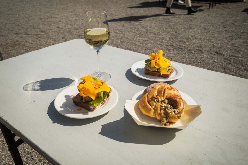 Ett glas vin och två mackor på ett bord i Vintervikens trädgårdskafé.