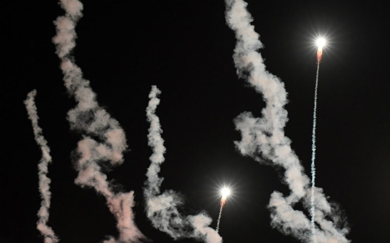 Rökpelare och två lysande raketer som skjuter upp över himlen.