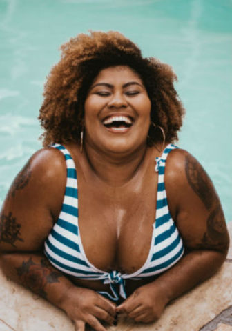En skrattande kvinna i bikini. Foto: Unsplash